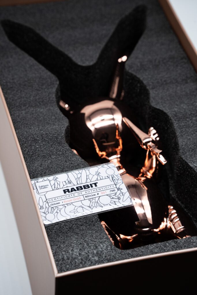 a balloon rabbit xl rose gold by editions studio in its open box, certificate of authenticity is visible on top of the box